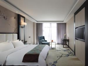 a hotel room with a large bed and a television at GreenTree Eastern Yancheng North Bus Station Boutique Hotel in Yancheng