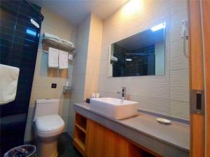 a bathroom with a sink and a toilet and a mirror at GreenTree Inn Heze Dingtao District Auto Town in Heze