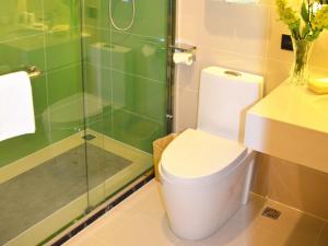La salle de bains est pourvue de toilettes et d'une douche en verre. dans l'établissement GreenTree Inn Shenyang Shengjing Hospital Shenyang Liaol Road Business Hotel, à Shenyang