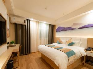 una camera d'albergo con un grande letto e una TV di VX Xuzhou Yunlong District Normal University Yunlong Mountain Scenic Spot Hotel a Xuzhou Altre 20 foto