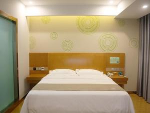 GreenTree Inn Bozhou Mengcheng District Red Star Macalline Business Hotel tesisinde bir odada yatak veya yataklar