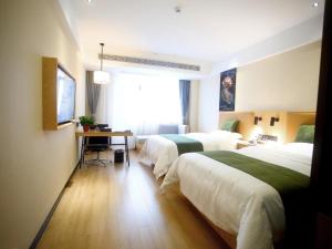 a hotel room with two beds and a desk at GreenTree Inn Fuyang Exhibition Center Business Hotel in Fuyang