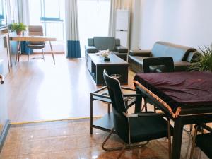 a living room with chairs and a couch and a table at GreenTree Inn Jiangsu Wuxi Hudai FuAn Commercial Plaza Business Hotel in Chang-she-chen