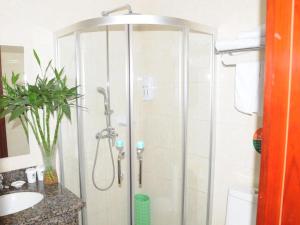 a shower stall in a bathroom with a sink at GreenTree Inn Jining Wenshang Baoxiang Temple Express Hotel in Wenshang