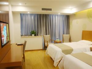 a hotel room with two beds and a television at GreenTree Inn Bozhou Mengcheng District Red Star Macalline Business Hotel in Mengcheng