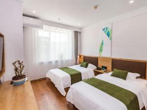 um quarto de hotel com duas camas e uma janela em GreenTree Inn Dalian Airport New District Xinzhaizi Express Hotel em Dalian