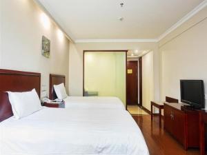 um quarto de hotel com uma cama grande e uma televisão em GreenTree Inn Anhui Huangshan Jiangjing District Tiandu Avenue Business Hotel em Huangshan