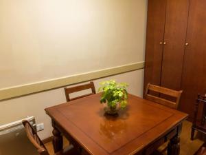 a wooden table with a vase of flowers on it at GreenTree Inn Jiangsu Taizhou Jingjiang Bus Station Express Hotel in Jingjiang +55 photos