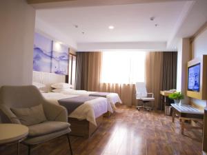 um quarto de hotel com duas camas e um sofá e uma televisão em GreenTree Eastern Taiyuan Jinyuan District Xinjinyu Road Hotel em Taiyuan