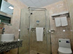 a bathroom with a shower with a toilet and a sink at Shell Jinzhou Ying County West Jincheng Street Hotel in Ying