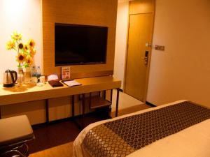 a hotel room with a desk with a television and a bed at GreenTree Inn Nanjing Provincial People's Hospital Express Hotel in Nanjing