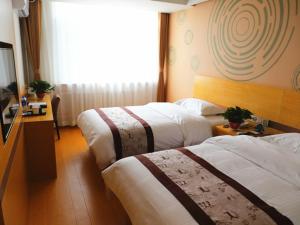 a hotel room with two beds and a window at GreenTree Inn Shenyang Shengjing Hospital Shenyang Liaol Road Business Hotel in Shenyang