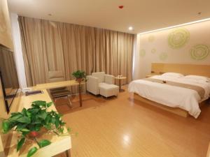 a hotel room with a bed and a desk and a room at GreenTree Inn Anyang Neihuang District Zaoxiang Road Hotel in Anyang
