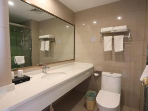une salle de bain avec un lavabo, des toilettes et un miroir dans l'établissement GreenTree Inn Suzhou Caohu Industrial Park Express Hotel, à Suzhou