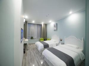 een hotelkamer met 2 bedden en een raam bij Shell Chuzhou North Bus Station Hotel in Chuzhou
