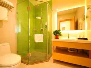 a bathroom with a shower and a toilet and a sink at GreenTree Inn Langfang Bazhou City Tangeerli Town Spa Business Hotel in Langfang