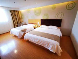 una camera d'albergo con due letti in una stanza di GreenTree Inn Taizhou Gaogang District Yonganzhou Town Yong'an North Road Express Hotel a Taizhou