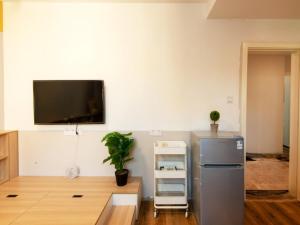 a kitchen with a refrigerator and a tv on the wall at GreenTree Shanghai Zhongshan North Road Apartment Hotel in Shanghai +20 photos