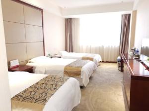 a hotel room with three beds and a window at GreenTree Alliance Xuzhou Gulou District Sanhuan North Road, Jinju Wuliuwan Hotel in Xuzhou