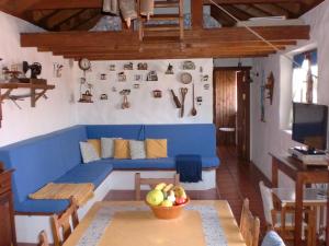 Casa Rural La Cuna في لوس سيلوس: غرفة معيشة مع أريكة زرقاء وطاولة