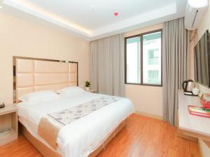 een slaapkamer met een groot bed en een raam bij Shell Jiaxing Jiashan Shenyou Road Hotel in Jiaxing
