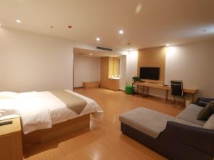 a hotel room with a bed and a couch at GreenTree Inn Anyang Neihuang District Zaoxiang Road Hotel in Anyang