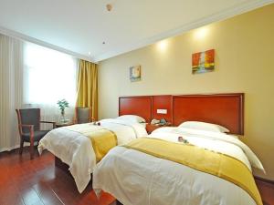 a hotel room with two beds and a desk at GreenTree Inn Linxi International Convention Center Express Hotel in Linyi