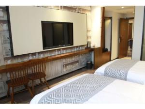 a hotel room with two beds and a flat screen tv at GME Huainan Tianjiaan District Chaoyang East Road Hotel in Huainan