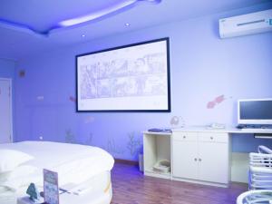 a room with a projection screen on a purple wall at GreenTree Inn ShanXi LuLiang FengShan Road Central Park Express Hotel in Luliang