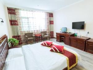 Dormitorio con cama, escritorio y TV en Green Alliance Langfang Xianghe County Xiushui Street PengDa furniture city Hotel, en Langfang