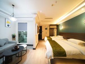 een grote slaapkamer met een groot bed en een bank bij GreenTree Alliance JiangXi ShangRao YiYang County ZhiMin Aveune YingBin Avenue Hotel in Yiyang