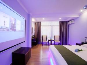 a hotel room with a bed and a projection screen at GreenTree Inn DanShui in Huizhou