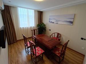 a dining room with a wooden table and chairs at GreenTree Inn Beijing Fangshan Liangxiang Suzhuang Express Hotel in Fangshan +28 photos