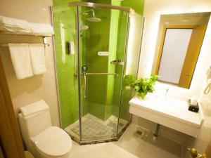 a bathroom with a shower and a toilet and a sink at GreenTree Inn Zhangjiakou City Chicheng County Xiacheng Avenue Oriental Yijing Express Hotel in Ch'ih-ch'eng-hsien