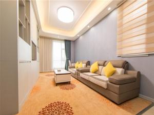 a living room with a couch and a table at GreenTree Eastern Yibin Yijian Road New City Plaza Hotel in Baixi