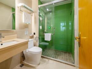 a bathroom with a shower and a toilet and a sink at GreenTree Inn Zhongshan West District Fuhua Road Hotel in Zhongshan