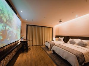 a large screen in a hotel room with two beds at GME Lu'an Yeji District Administrative Center Hotel in Lu'an