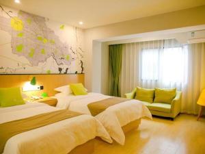 a hotel room with two beds and a map on the wall at Vatica Fuyang Linquan County Jiangziya Square Hotel in Fuyang