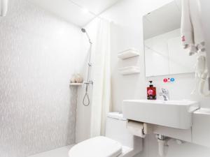 Shell Taiyuan City Xiaodian District Kangning Street Foxconn Hotel في تاييوان: حمام ابيض مع مرحاض ومغسلة