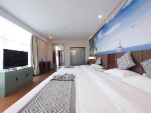 a large bedroom with a large bed and a tv at GME Hefei Feidong county High Speed Railway Station Longquan East Road Hotel in Hefei