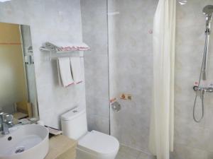 a bathroom with a shower and a toilet and a sink at Shell Shangxi Xinzhou Dai County 108 State Road Hotel in Dai