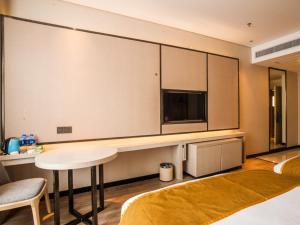 um quarto com uma grande parede com uma mesa e uma televisão em GreenTree Eastern Lianyungang Jiaruibao Plaza Hotel em Lianyungang