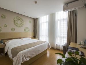 um quarto com uma cama grande e 2 janelas em GreenTree Inn Chengde Shuangluan District Xinhui Wan Business Hotel em Chengde
