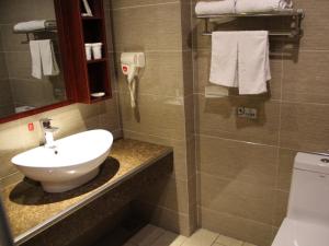 ein Badezimmer mit Waschbecken und Toilette in der Unterkunft GreenTree Inn Jiangsu Nantong Tongzhou Shiji Avenue Jianghaihuangdu Express Hotel in Tongzhou + 20 Fotos