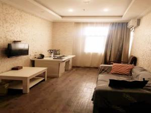 a living room with a couch and a table at GreenTree Inn Zhejiang Ningbo Dongqian Lake Yinxian Avenue North Mozhi Road Business Hotel in Ningbo