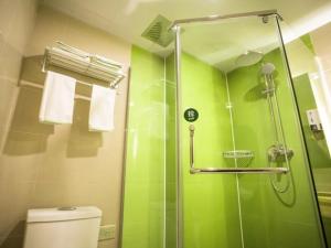 een groene badkamer met een douche en een toilet bij GreenTree Inn Heze Shanxian Huxi South Road Express Hotel in Shan