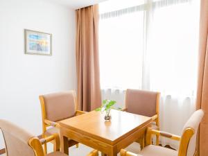 une salle à manger avec une table et des chaises en bois dans l'établissement GreenTree Inn Huzhou Zhili Fortune Plaza Wuxing Avenue Express Hotel, à Huzhou