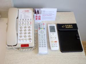 um telefone, uma calculadora e uma carteira numa mesa em Shell Nanjing City Qixia District Baguazhou Hotel em Nanquim