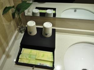 a counter with three cups on it in a bathroom at Vatica Xuzhou Suining Bus Station Building Materials City Hotel in Suining