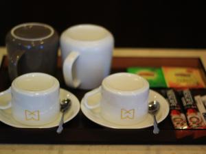 two cups and saucers on a table with spoons at GME Hefei Feidong county High Speed Railway Station Longquan East Road Hotel in Hefei